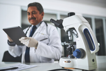 Microscope, science and tablet with man in laboratory for discovery, innovation or research. Medical, pharmaceuticals and technology with mature scientist at desk for analysis of dna or sample