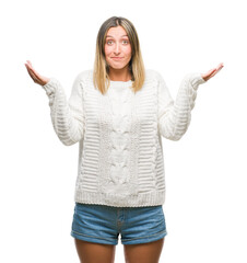 Young beautiful woman wearing winter sweater over isolated background clueless and confused...