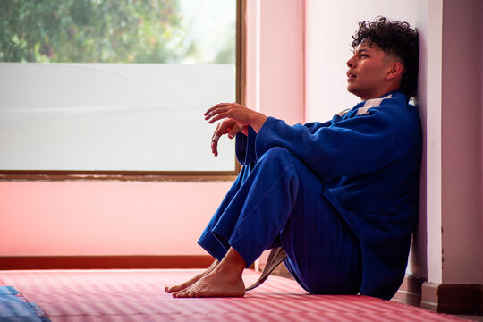 Judo fighter portrait resting in dojo with some trees at background