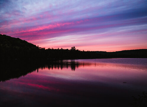Colorful sunset over tranquil Shaw Pond in the north Maine woods