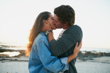 Obraz premium Beach, kiss and couple with love, romance and happiness with anniversary, vacation and relationship. Seaside, hug and man with woman, marriage and getaway trip for honeymoon, nature and affection