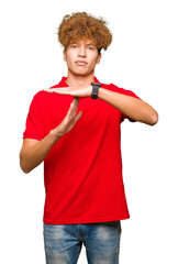 Young handsome man with afro hair wearing red t-shirt Doing time out gesture with hands, frustrated...
