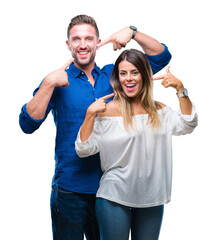 Fototapeta premium Young couple in love over isolated background smiling confident showing and pointing with fingers teeth and mouth. Health concept.