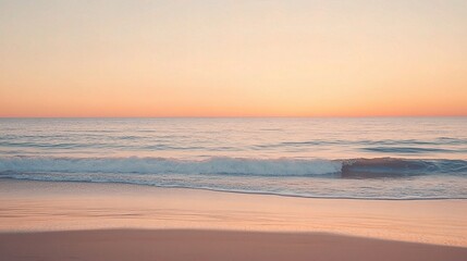 Obraz premium Serene Sunset Seascape: Gentle waves caress the sandy shore as the sun dips below the horizon, painting the sky with soft, peachy hues. A tranquil scene perfect for relaxation and contemplation.