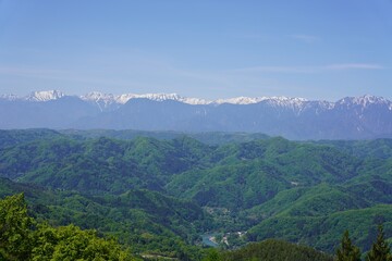 Naklejka premium 信州 大岡 新緑の里山と残雪の北アルプス 常念岳 大天井岳 餓鬼岳 