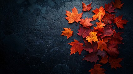 A striking autumnal composition of orange and red maple leaves scattered on a dark, textured background, with a soft spotlight highlighting the rich colors