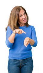 Middle age beautiful woman wearing winter sweater over isolated background In hurry pointing to...