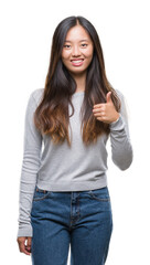 Obraz premium Young asian woman over isolated background doing happy thumbs up gesture with hand. Approving expression looking at the camera with showing success.