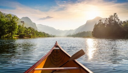Fototapeta premium On a bright and sunny morning, a slender canoe drifts gently across a narrow river that winds through a tranquil lake, surrounded by lush greenery and the soft glow of dawn’s light
