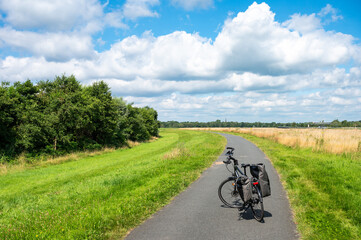 Trekking bike with paniers stading on a cycling track along the River Ochtum, Bremen, Germany