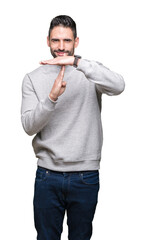 Young handsome man wearing sweatshirt over isolated background Doing time out gesture with hands,...
