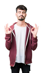 Young handsome man over isolated background relax and smiling with eyes closed doing meditation gesture with fingers. Yoga concept.