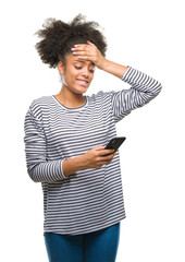 Young afro american woman texting using smartphone over isolated background stressed with hand on head, shocked with shame and surprise face, angry and frustrated. Fear and upset for mistake.