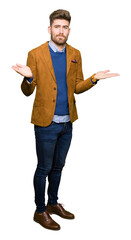 Young handsome business man clueless and confused expression with arms and hands raised. Doubt...