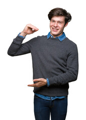 Young handsome elegant man over isolated background gesturing with hands showing big and large size sign, measure symbol. Smiling looking at the camera. Measuring concept.