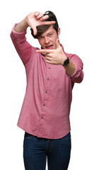 Fototapeta premium Young handsome business man over isolated background smiling making frame with hands and fingers with happy face. Creativity and photography concept.