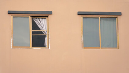 Two windows with curtains on them. One window is open. The other window is closed