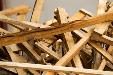 A pile of wood with a brown splinter on it. The pile is made up of many pieces of wood, some of which are broken. Scene is somewhat sad, as the pile of wood seems to be discarded