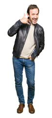 Fototapeta premium Middle age handsome man wearing black leather jacket smiling doing phone gesture with hand and fingers like talking on the telephone. Communicating concepts.
