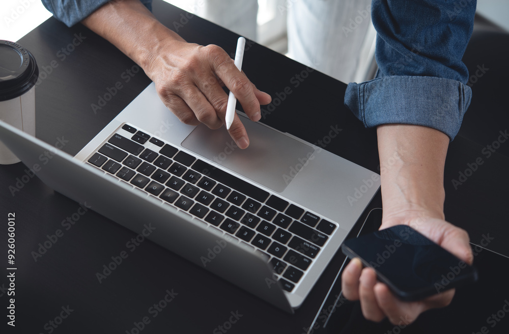Poster close up of business man working on laptop computer and using mobile phone with digital tablet on of