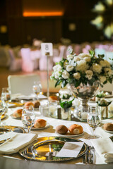 A beautifully decorated wedding table with white flowers, candles, and gold accents