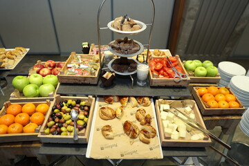 Close-up of a beautifully arranged breakfast buffet with various breads, pastries, and fruits