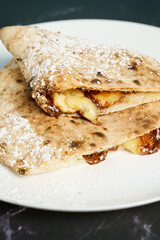 Italian dessert - calzone filled with chocolate, banana and powdered sugar