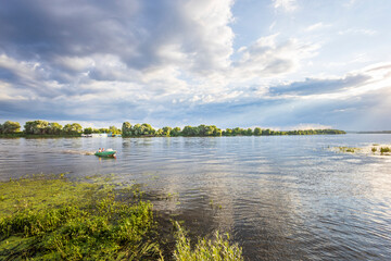 A serene river scene: a small boat peacefully floats among lush greenery, fluffy clouds in the sky, and a warm sun, bringing calm