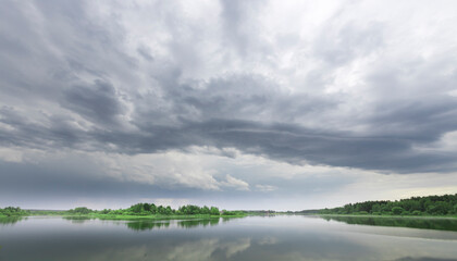 Fototapeta premium A cloudy sky with a lake in the background