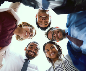 Business people, group and low angle for portrait, huddle or happy with hug, solidarity and diversity. Team, scrum or circle with support, connection or link for synergy in office at insurance agency
