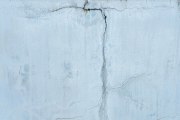 A grungy blue-painted wall with a rough, textured surface
