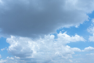 Fluffy white clouds drifting across a bright blue summer sky