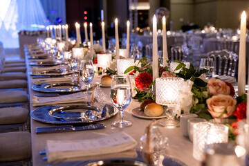 Long and elegant wedding table with candles and floral centerpiece