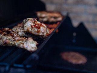 A couple of pork pieces resting on a gas smoker