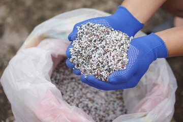 Close up hands hold mixed chemical fertilizer. Concept;  chemical fertilizer production use in...