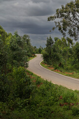 A country side Road in the forests of Western Ghats with an overcast cloudscape in Karnataka, India.