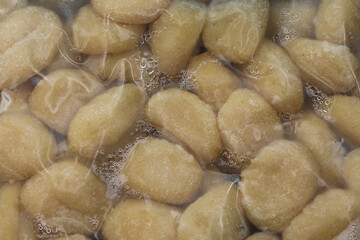Vacuum-sealed pack of gnocchi, showing fresh, soft, pillowy dumplings. The clear packaging highlights the golden, potato-based pasta, ready for cooking.