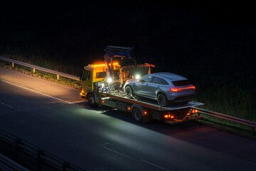 Car rescue transports a troubled luxury car .towing truck during works on a highway