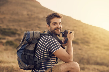 Happy man, hiking and portrait in exploration, photography and nature for travel, adventure or vacation. Male person, camera and countryside for discovery, journey and mountain for outdoor recreation