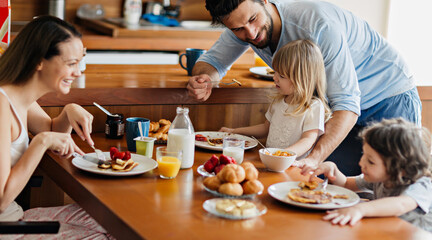 Happy family enjoying breakfast together in cozy kitchen