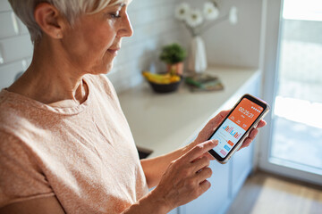 Senior woman using fitness tracking app on smartphone