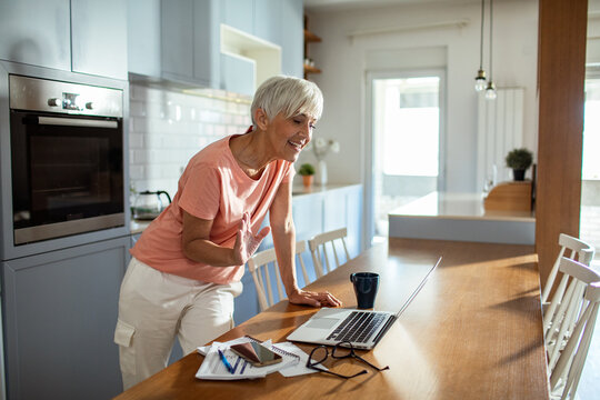 Senior woman managing finances on laptop at home