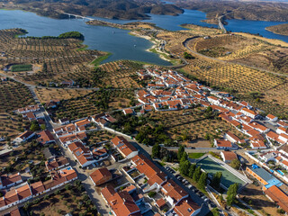 Aerial view of Amieira village in Alentejo, Portugal, with the Amieira river beach in the background, set against the vast Alqueva dam reservoir.