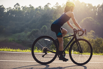 Obraz premium Woman cyclist riding bike at summer park