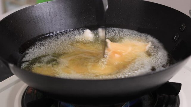 Process Deep Frying Crackers in the Hot Oil, Kitchen Step by Step. Goreng Kerupuk, Indonesian Crackers