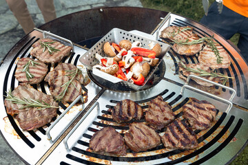 Swiss beef steak marbled beef seasoned with sprigs rosemary mushrooms pepper is cooking on the grill surface grill is in the backyard of your chalet. Outdoor cooking. Meat with grill marks.
