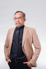 A businessman in a suit and tie stands in front of a white background. He is wearing a black tie and glasses