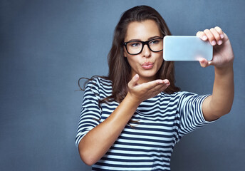 Woman, glasses and selfie with air kiss, optometry and confidence on gray studio background. Female...