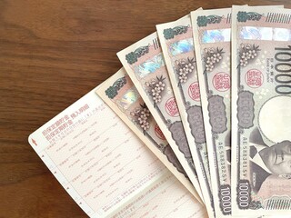 机上の通帳と五万円