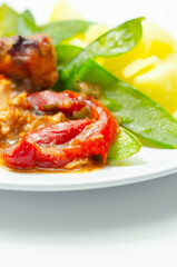 A plate of food with a piece of meat and a side of potatoes and mangetout